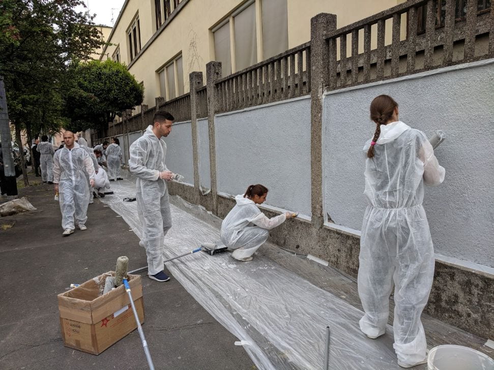 Venti giovani “imbianchini” per ripulire il muro della scuola dai graffiti