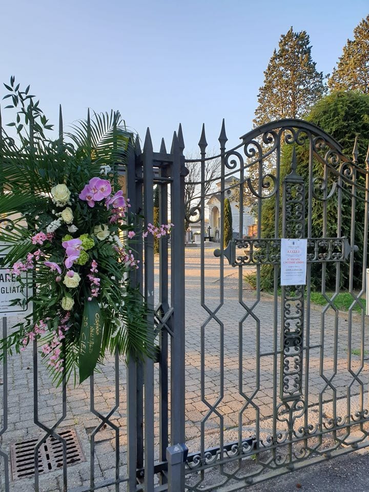 Coronavirus, Cislago omaggio floreale per tutti i defunti sul cancello del cimitero